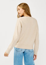 [Color: Heather Petal] A back facing image of a blonde model wearing a classic cozy v-neck pullover sweater with ribbed trims. Perfect for casual outings and the office. 