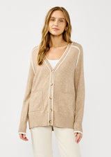 [Color: Taupe/White] A front facing image of a blonde model wearing a light brown button front cardigan with white border stripes. Featuring essential patch pockets and a relaxed mid length silhouette. 