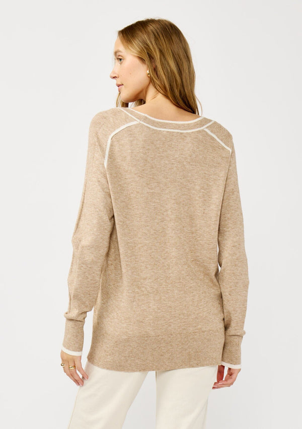 [Color: Taupe/White] A back facing image of a blonde model wearing a light brown button front cardigan with white border stripes. Featuring essential patch pockets and a relaxed mid length silhouette. 