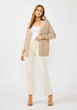 [Color: Taupe/White] A front facing image of a blonde model wearing a light brown button front cardigan with white border stripes. Featuring essential patch pockets and a relaxed mid length silhouette. 