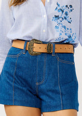 [Color: Camel] A front facing image of a model wearing a vintage-inspired western buckle belt. 