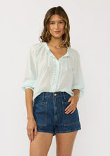 [Color: Mint] A front facing image of a brunette model wearing a sheer mint blouse with lace trims. Featuring a round neckline, button front, and 33/4 length sleeves with elastic cuffs. A lightweight boho cotton blouse. 