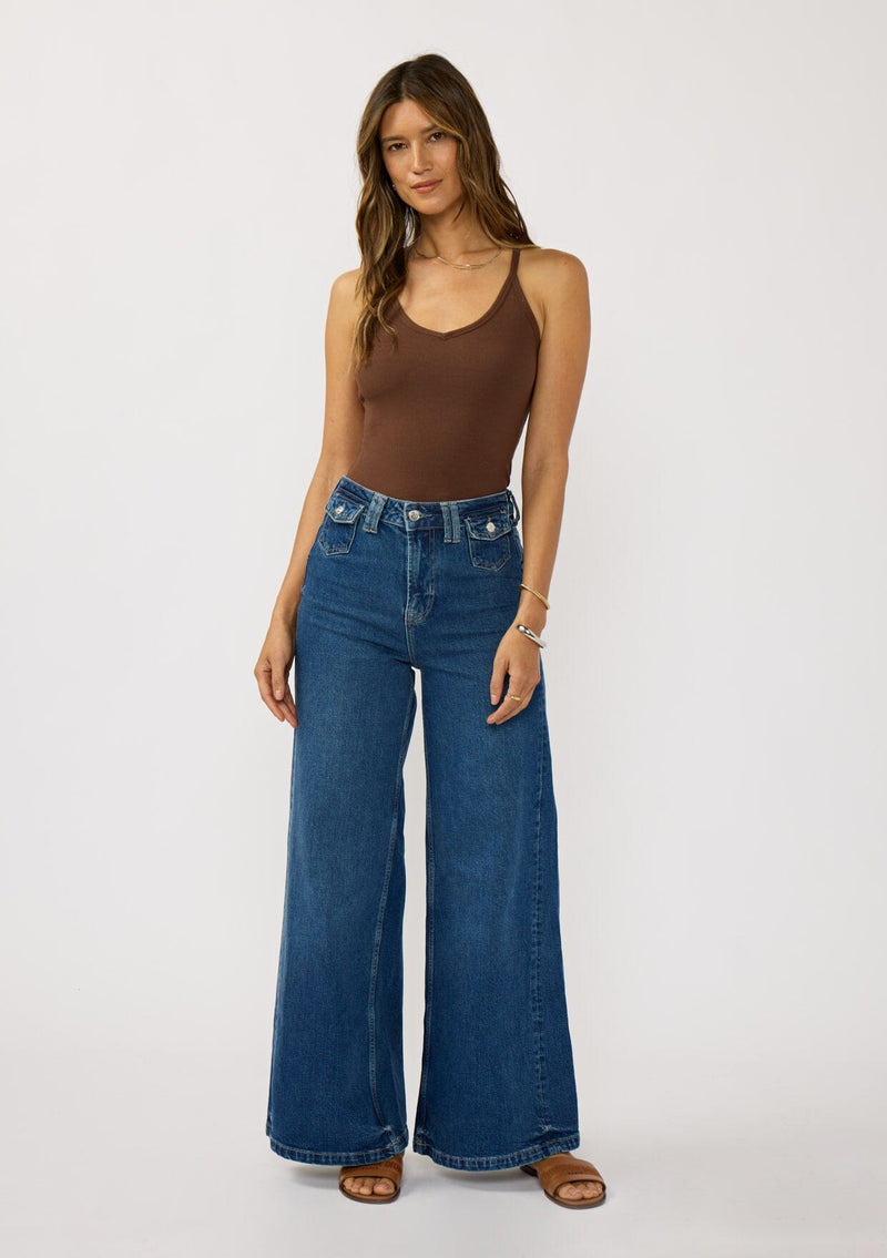 [Color: Chocolate] A brunette model wearing a brown micro ribbed tank top with a v-neckline and racerback. A basic everyday tank top 