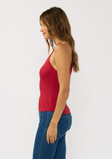 [Color: Wine Red] A side facing image of a brunette model wearing a red micro ribbed tank top with a v-neckline and racerback. A basic everyday tank top.