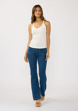 [Color: White] A front facing image of a brunette model wearing a white micro ribbed tank top with a v-neckline and racerback. A basic everyday tank top.