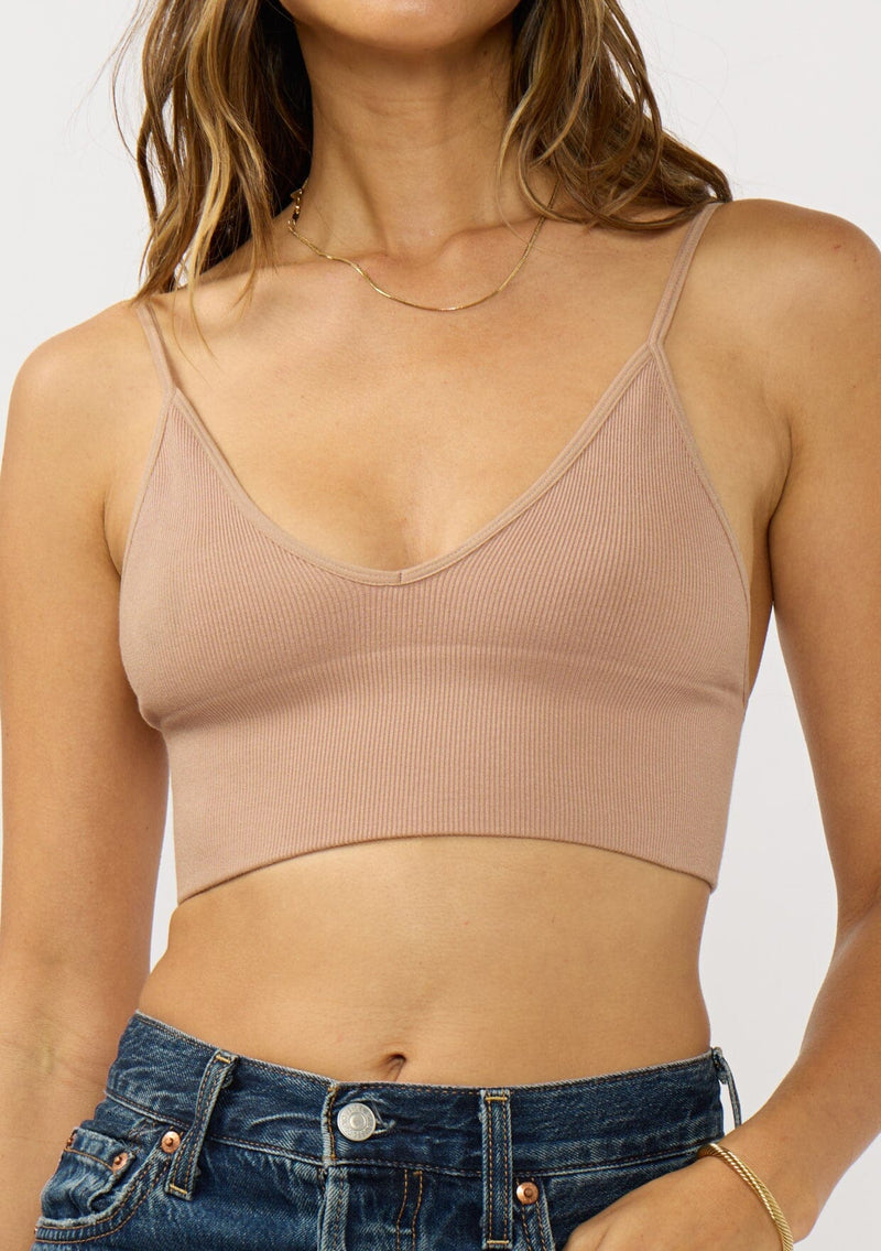 [Color: Taupe] A detail image of a brunette model wearing a basic taupe bralette cami with a slim stretchy fit and a v-neckline.