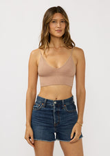 [Color: Taupe] A front facing image of a brunette model wearing a basic taupe bralette cami with a slim stretchy fit and a v-neckline.