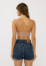 [Color: Taupe] A back facing image of a brunette model wearing a basic taupe bralette cami with a slim stretchy fit and a v-neckline.