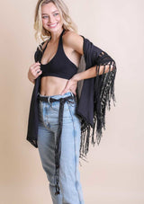 [Color: Black] A blonde model wearing a a long bohemian macrame belt with beads wrapped around denim bottoms.