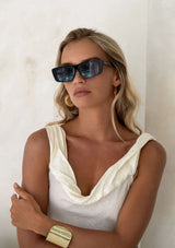 [Color: Black]: Retro style sunglasses with a blue lens in a black frame color. 100% UVA/UVB protection.