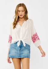 [Color: Off White/Fuchsia] A front-facing image of a blonde model wearing a white sheer tie-front top, featuring delicate pink floral embroidered cutouts along the sleeves.