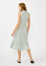 [Color: Grey Mist] A back facing image of a blonde model wearing a light green sleeveless shirt dress with a collared neckline, button front, and a self tie waist belt. 