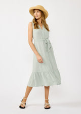 [Color: Grey Mist] A front facing image of a blonde model wearing a light green sleeveless shirt dress with a collared neckline, button front, and a self tie waist belt. 