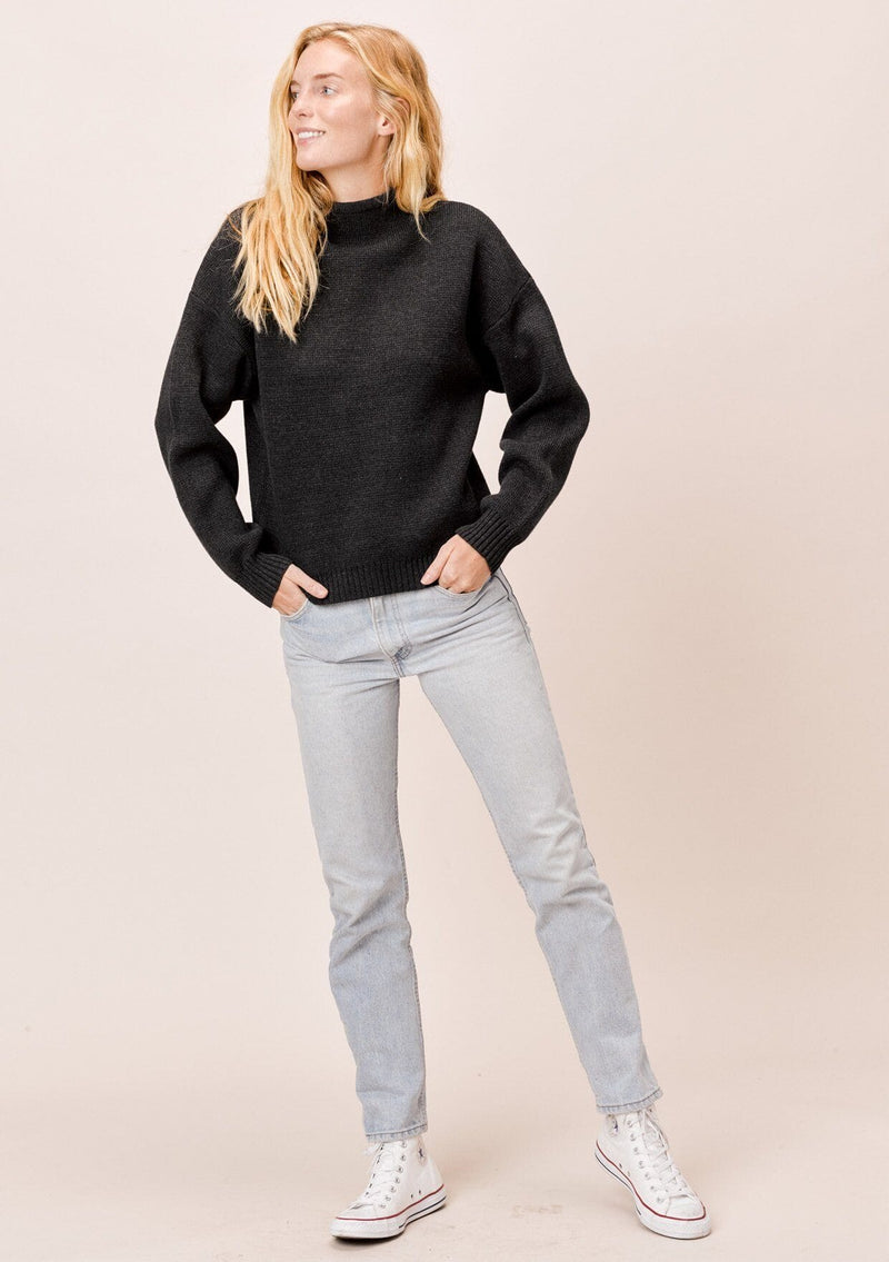 [Color: Charcoal] A blonde model wearing a charcoal sweater with an elegant funnel neck, a concealed zip closure at the back neck, and contrast ribbed details. A basic cold weather sweater for the fall season. 