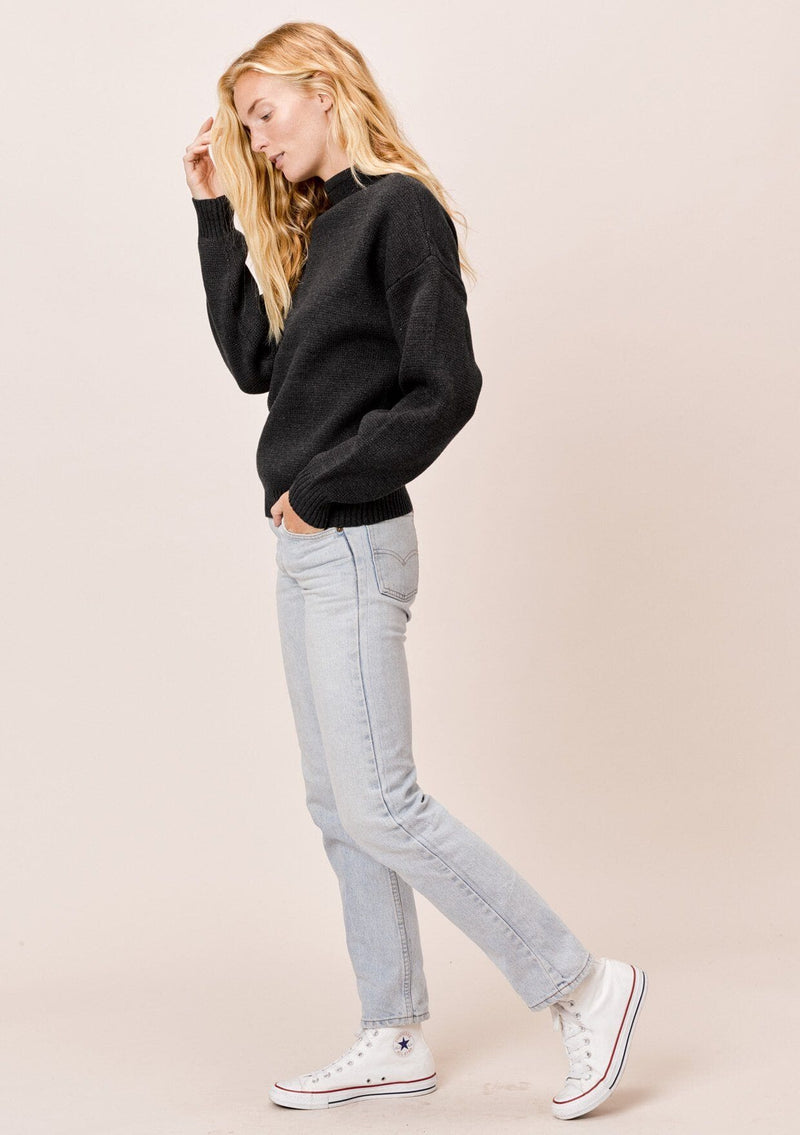 [Color: Charcoal] A blonde model wearing a charcoal sweater with an elegant funnel neck, a concealed zip closure at the back neck, and contrast ribbed details. A basic cold weather sweater for the fall season. 