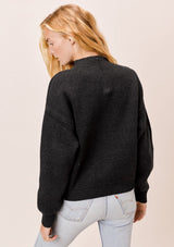 [Color: Charcoal] A blonde model wearing a charcoal sweater with an elegant funnel neck, a concealed zip closure at the back neck, and contrast ribbed details. A basic cold weather sweater for the fall season. 