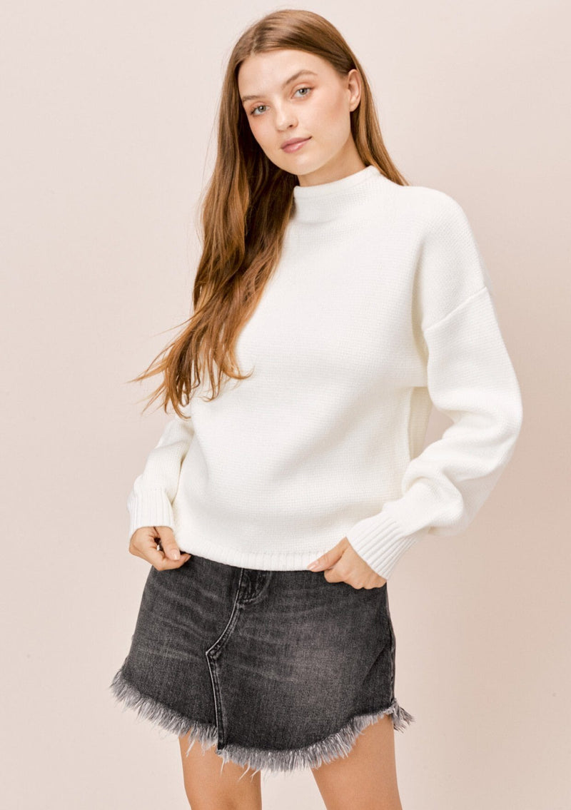 [Color: Charcoal] A blonde model wearing a white sweater with an elegant funnel neck, a concealed zip closure at the back neck, and contrast ribbed details. A basic cold weather sweater for the fall season. 