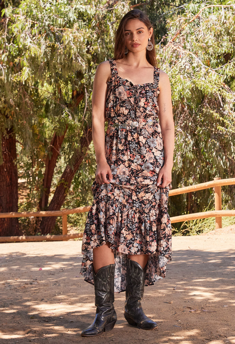 Lovestitch fall outfitting inspiration. Fall floral maxi dress layered over a sheer lace mesh long sleeve top for the perfect bohemian fall style. Paired here with black vintage cowgirl boots, silver boho earrings, and a chic belt.
