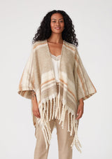 [Color: Taupe/Rust] A front facing image of a brunette model wearing a soft sweater shawl in a taupe and cream stripe. With a fringed hemline, a mid length silhouette, an open front, and long sleeves. 
