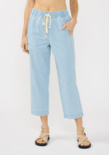 [Color: Light Denim Blue] A front facing image of a blonde model wearing a casual light blue cropped pant with an elastic waistband, drawstring, and side pockets. 