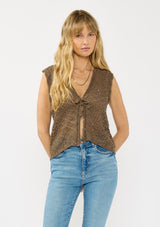 [Color: Brown] A front facing image of a blonde model wearing a brown pointelle knit vest with a tie front and sequins. 
