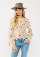 [Color: Natural] A front facing image of a blonde model wearing a circular crochet knit top with a round neckline and long sleeves. A spring boho top for casual and beach styling. 