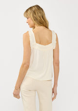 [Color: Tea] A back facing image of a blonde model wearing a bohemian off white tank top with a button front, square neckline, and wide straps with ruffle trims. 