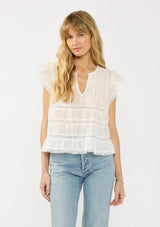 [Color: White] A front facing image of a blonde model wearing a white lace top with a v neckline, flutter sleeves and pintuck details. A vintage inspired lace top for the spring season.