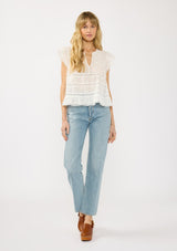 [Color: White] A front facing image of a blonde model wearing a white lace top with a v neckline, flutter sleeves and pintuck details. A vintage inspired lace top for the spring season.