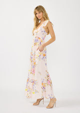 [Color: Blush/Dusty Blue] A side facing image of a blonde model wearing a pink floral print maxi dress with ruffled sleeves, adjustable straps, and side pockets. 