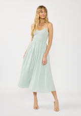 [Color: Mint] A front facing image of a blonde model wearing a mint green midi dress with a smocked bust, spaghetti straps, and ruffle trim details.