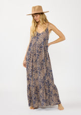 [Color: Navy/Natural] A front facing image of a blonde model wearing a flowy bohemian floral print maxi dress with adjustable spaghetti straps, a v neckline, and side pockets.