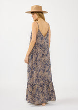[Color: Navy/Natural] A back facing image of a blonde model wearing a flowy bohemian floral print maxi dress with adjustable spaghetti straps, a v neckline, and side pockets.