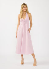 [Color: Lilac] A front facing image of a blonde model wearing a light purple pink maxi dress with a smocked halter neckline, v neckline, and side pockets. 
