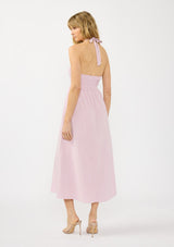 [Color: Lilac] A back facing image of a blonde model wearing a light purple pink maxi dress with a smocked halter neckline, v neckline, and side pockets. 