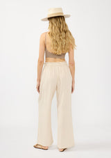 [Color: Natural] A back facing image of a blonde model wearing a beige crochet vest, tank top, and wide-leg pants with a drawstring waist and side pockets.