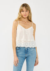 [Color: White] A front facing image of a blonde model wearing a white cami with an eyelet hem, v neckline with ruffle trim, and adjustable spaghetti straps. 