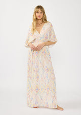 [Color: Almond/Rose] A front facing image of a blonde model wearing a pink and yellow boho print maxi dress with kimono sleeves, a smocked waist, a tie back detail, and side slits. The perfect vacation dress. 