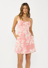 [Color: Salmon/Ivory] A front facing image of a pink floral mini dress with a sweetheart neckline, spaghetti straps, side pockets, and a smocked back. 