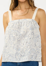 [Color: Natural/Blue] A detail image of a brunette model wearing a blue and white bohemian tank top with a square neckline and adjustable straps with lace trim.