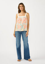 [Color: Natural/Coral] A front facing image of a brunette model wearing a coral floral tank top with solid back and a square neckline. 