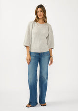 [Color: Light Heather Grey] A front facing image of a brunette model wearing a grey sweater with a crew neckline and three quarter length sleeves. 