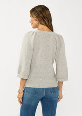 [Color: Light Heather Grey] A back facing image of a brunette model wearing a grey sweater with a crew neckline and three quarter length sleeves. 