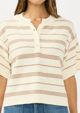 [Color: Vanilla/Taupe] A detail image of a brunette model wearing an ivory and beige cotton striped sweater top with short sleeves and a button front. 