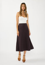 [Color: Chocolate] A front facing image of a brunette model wearing a white bodysuit with a brown ribbed knit maxi skirt with an elastic waistband. 
