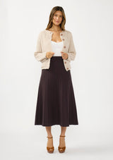 [Color: Chocolate] A front facing image of a brunette model wearing a brown ribbed knit maxi skirt with an elastic waistband. Styled with a beige knit sweater. 