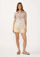 [Color: Fawn/Stone] A front facing image of a brunette model wearing a beige collared sweater top with a striped design, a button front, and short sleeves. 