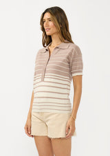 [Color: Fawn/Stone] A side facing image of a brunette model wearing a beige collared sweater top with a striped design, a button front, and short sleeves. 