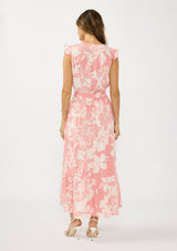 [Color: Salmon/Ivory] A back facing image of a brunette model wearing a coral floral print maxi dress with a flutter cap sleeves, a split v neckline, a tiered skirt, and a waist belt. 