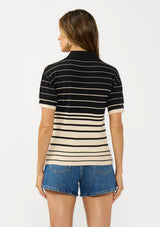 [Color: Black/Buttercream] A back facing image of a brunette model wearing a black and beige collared sweater top with a striped design, a button front, and short sleeves. 